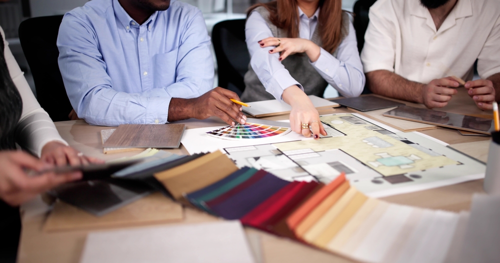 Designer,Group,At,Desk,Discussing,Custom,House,Remodel